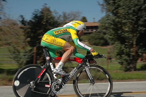 A man in green and yellow lira riding a bike through the countryside